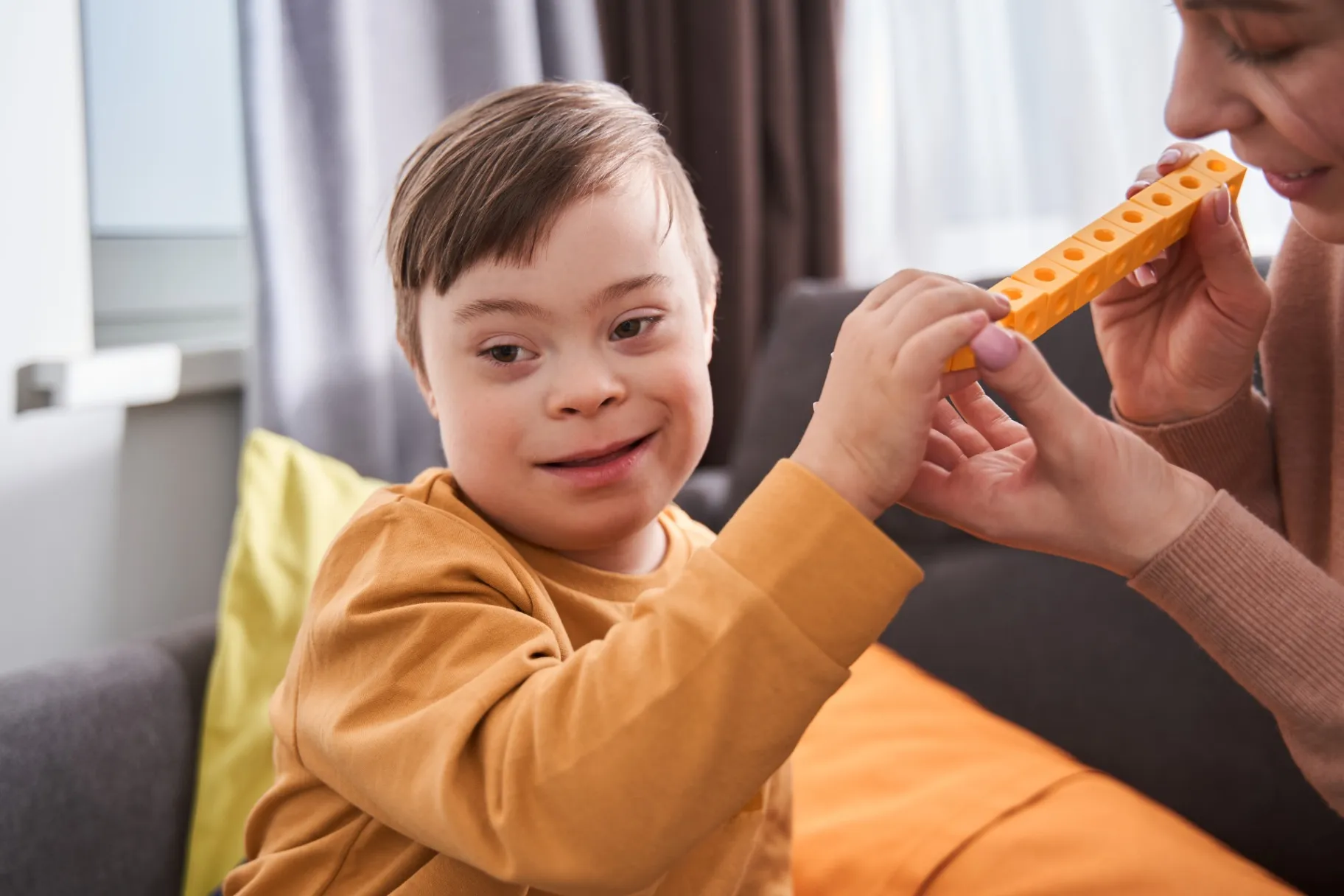 Caucasian mother playing at the building kit with her son